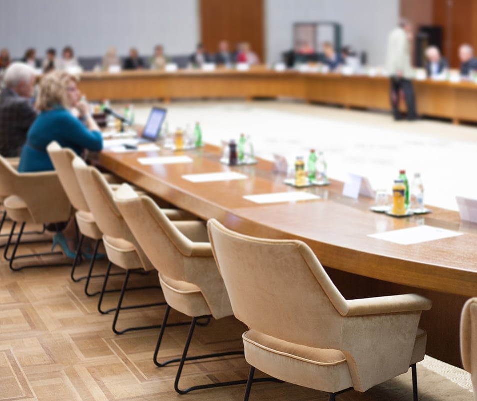 People set around a large table for policy discussion.