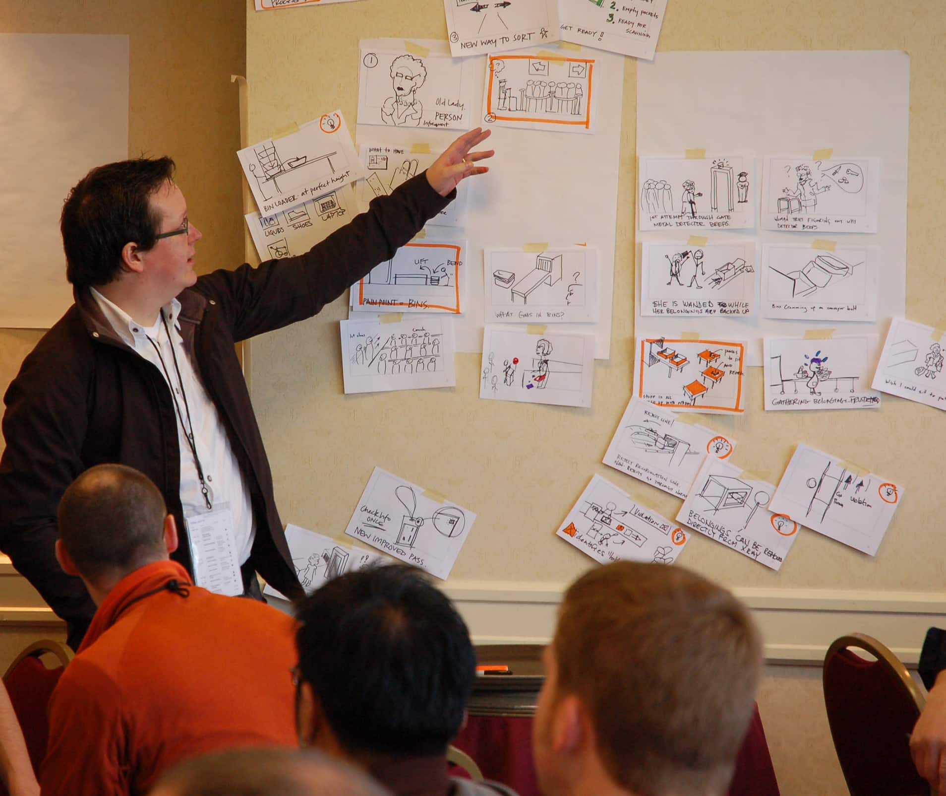 A designer presents work in front of a group.